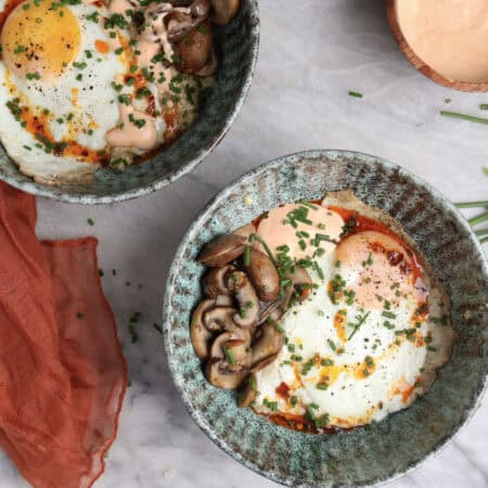 Two Savory oatmeal bowls loaded with oatmeal, fried egg, mushrooms and a homemade sriracha mayo.