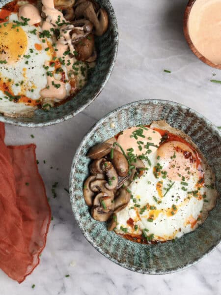 Two Savory oatmeal bowls loaded with oatmeal, fried egg, mushrooms and a homemade sriracha mayo.